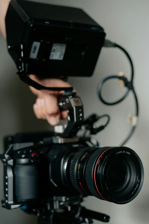 someone holding a camera with two hands and a lens