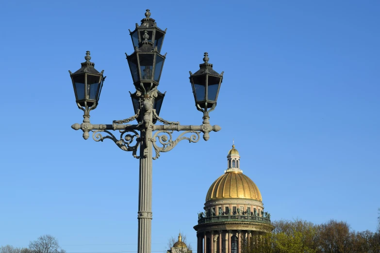 a street light next to a tower with a gold dome on top