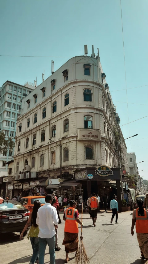 people walking down a street in front of a tall building