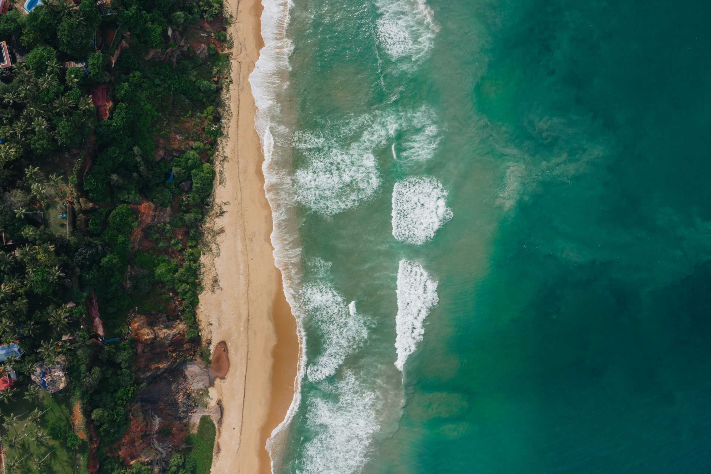 an aerial view of an empty beach and a body of water