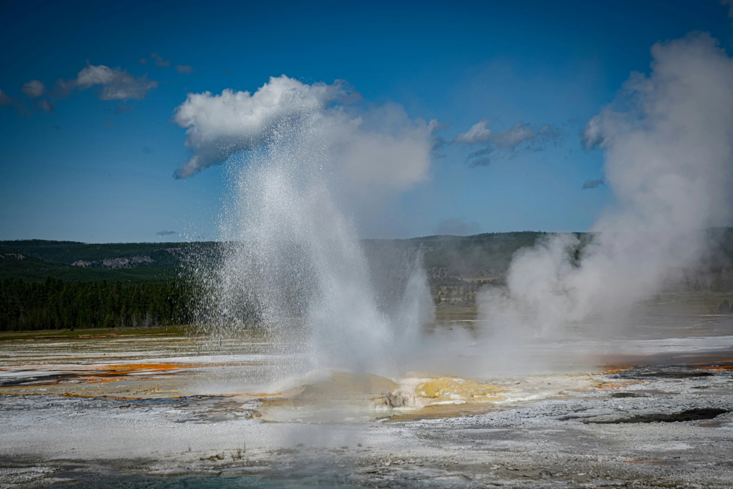 an old - fashioned steamy geyser spewing water into the sky