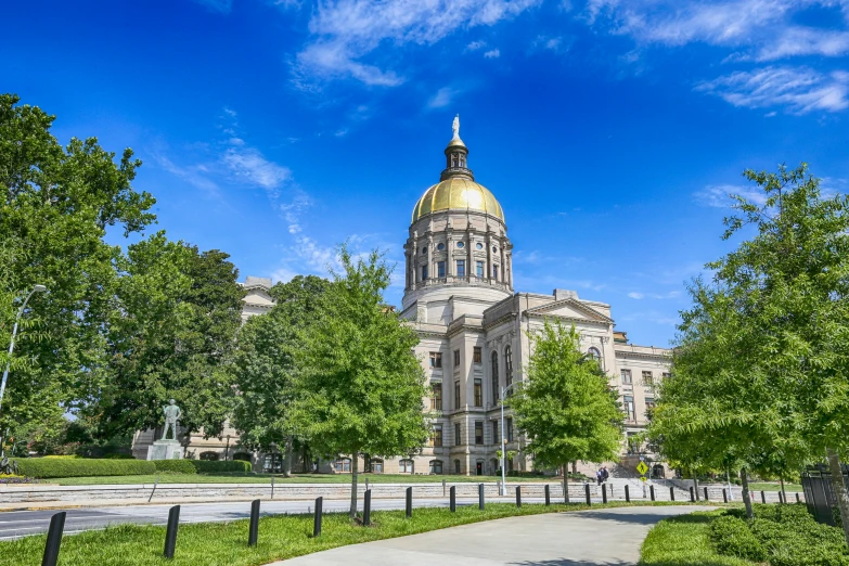 a yellow domed building with trees and a pathway