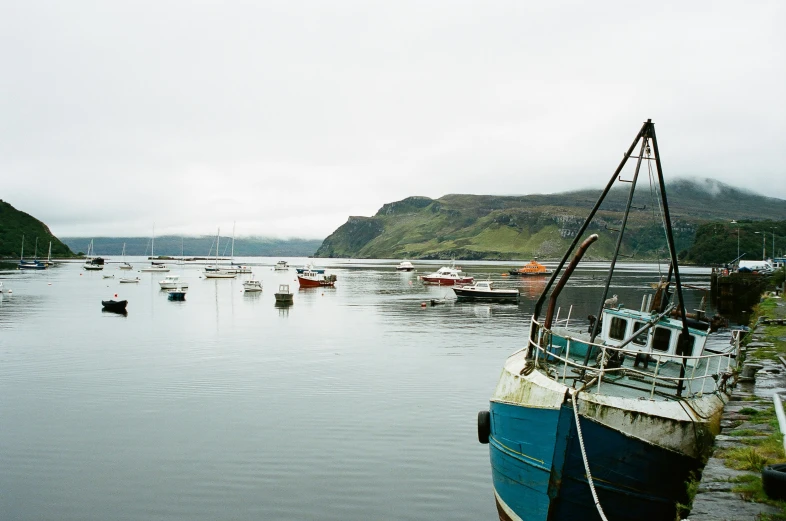 fishing boats in an alpine harbor during a gray sky