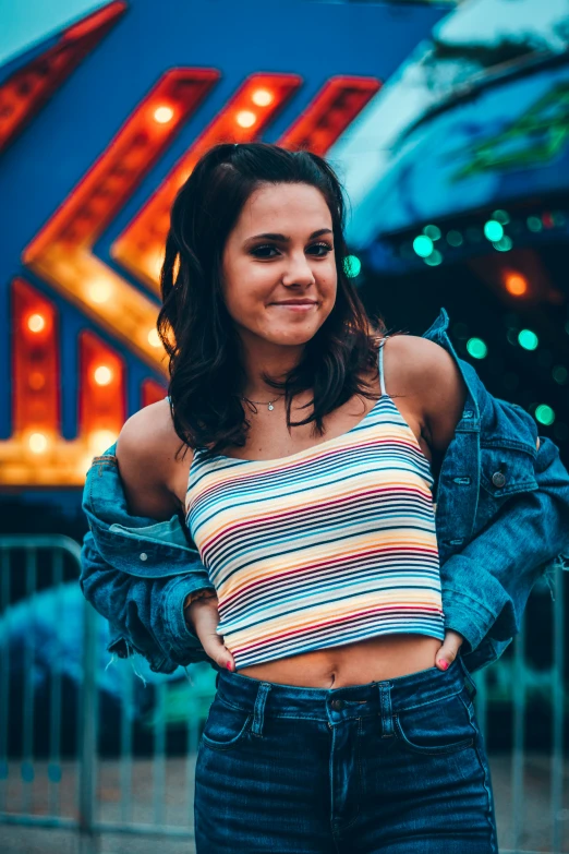 a woman standing in front of a colorful sign