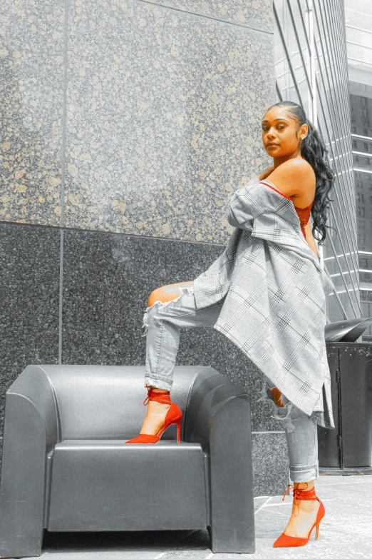 a girl with orange shoes is sitting on an armchair