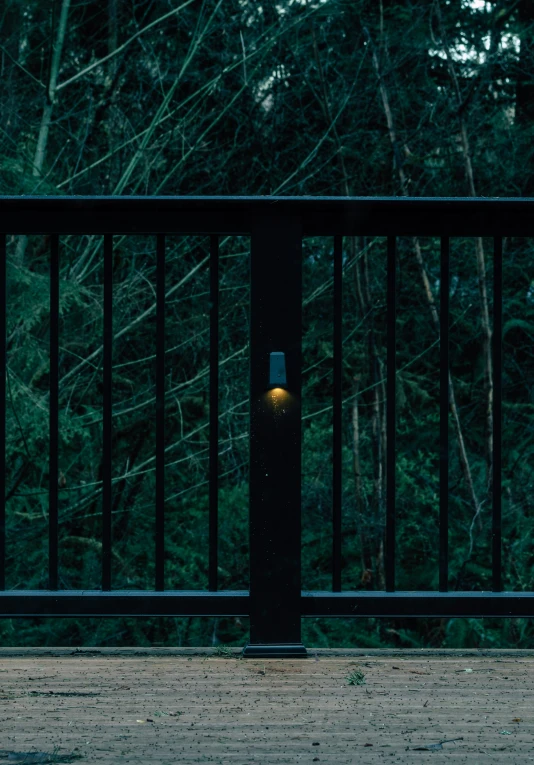 a black fence with a yellow light at it