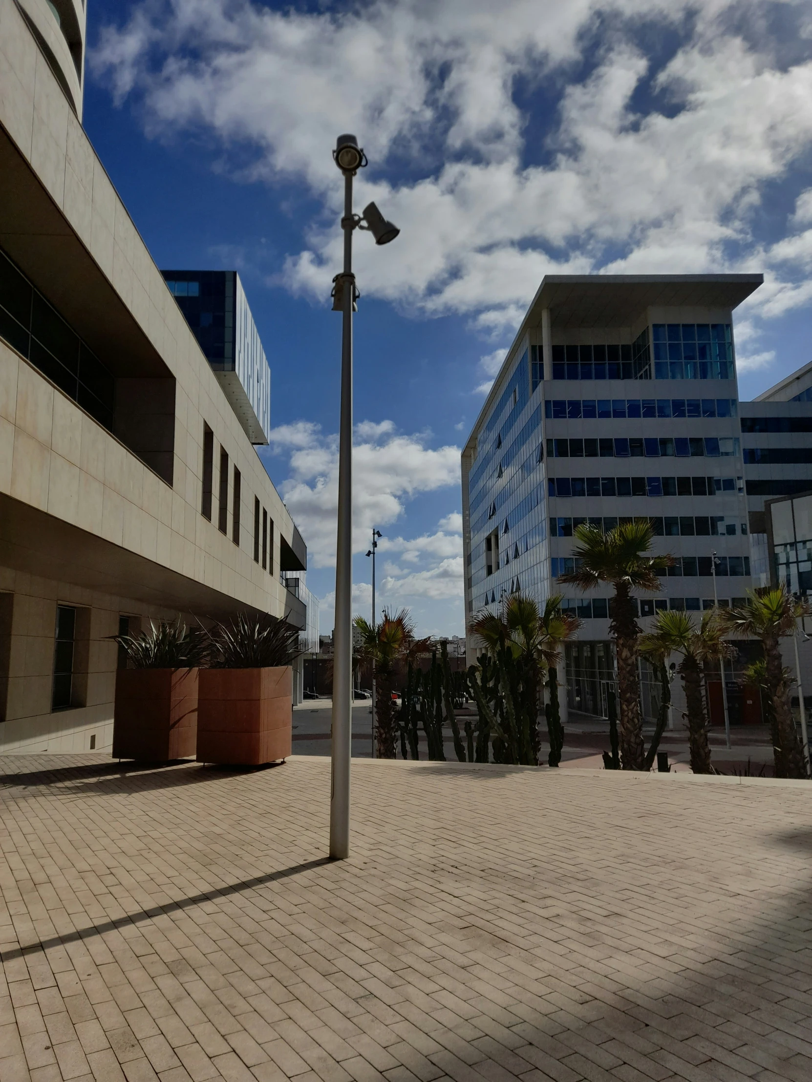 light posts are lined up along an empty brick walkway