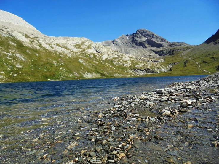 a rocky beach that is surrounded by mountains