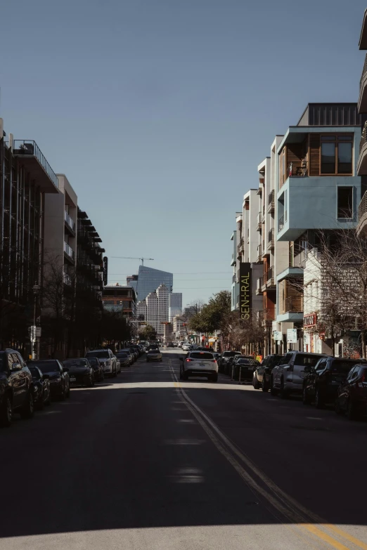 the long street has cars parked near it