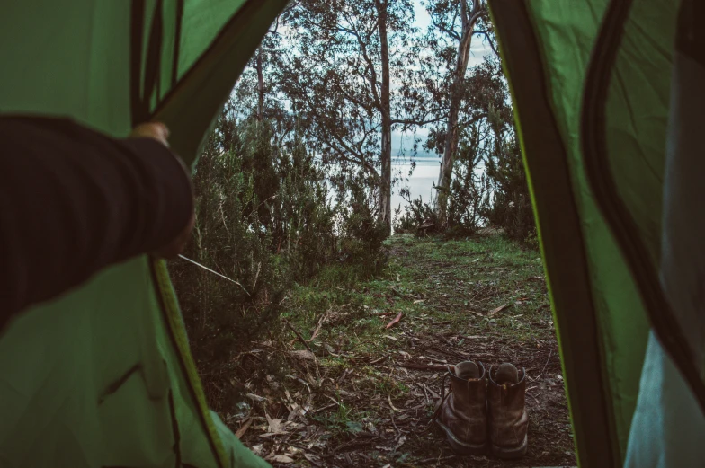 someone putting their shoes in their tent looking through it