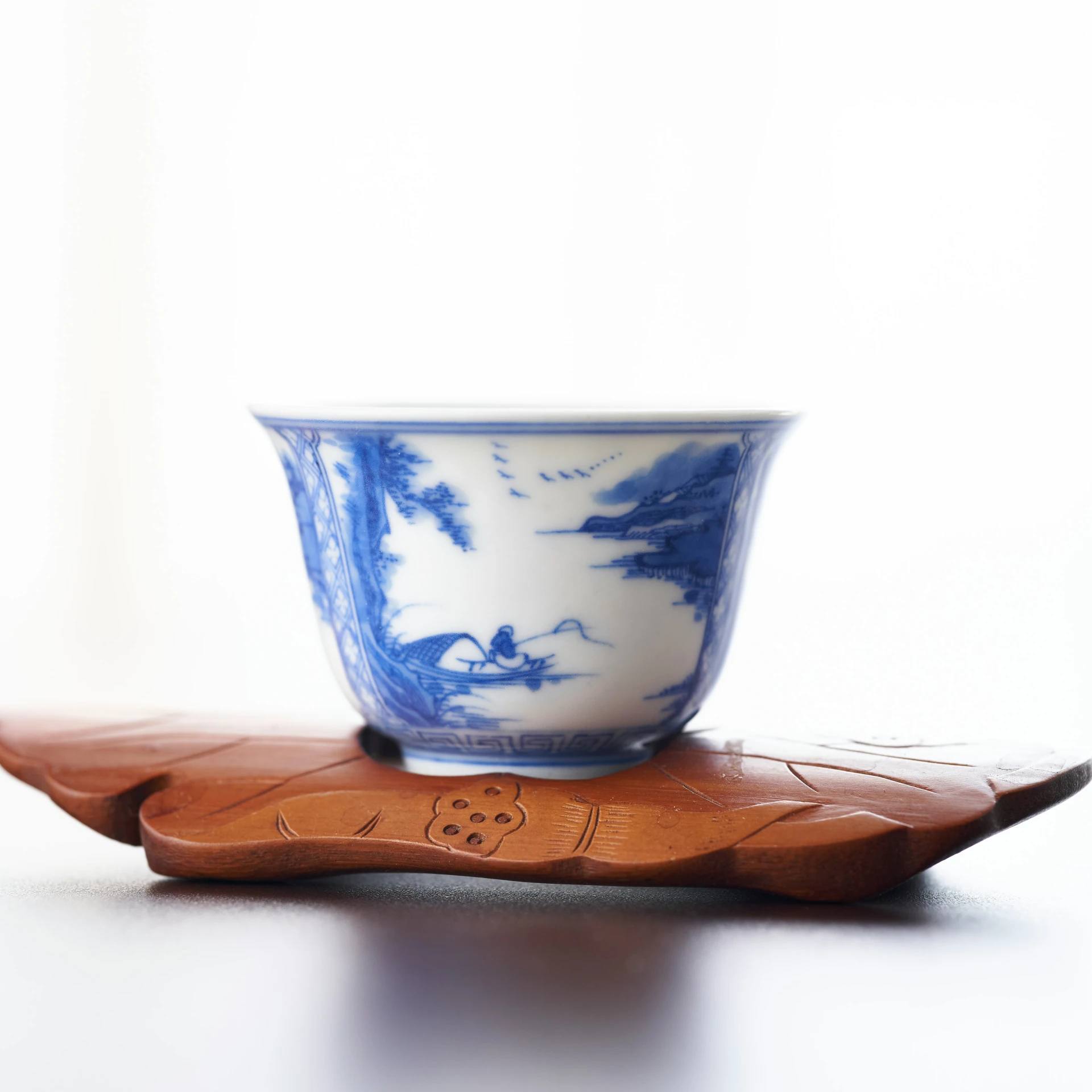 a white and blue bowl on top of a wooden plate