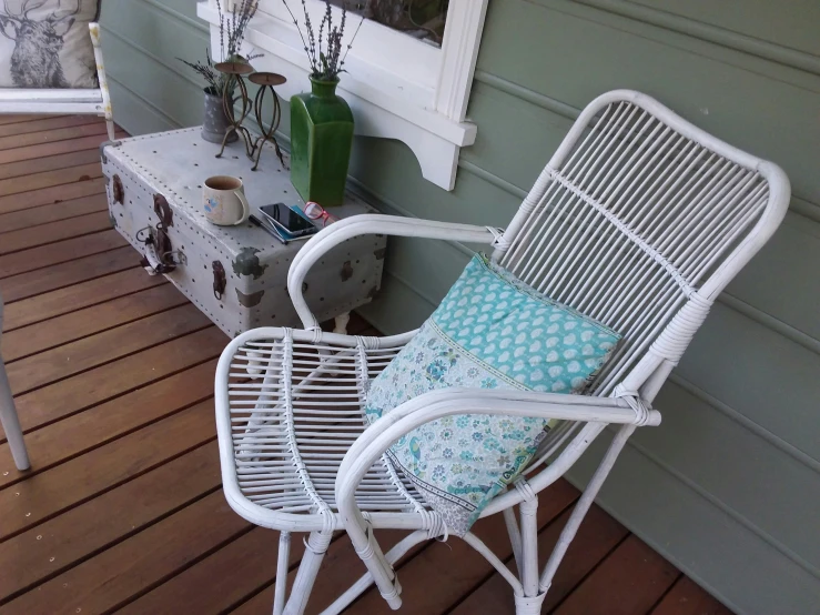 a white chair is on the front porch