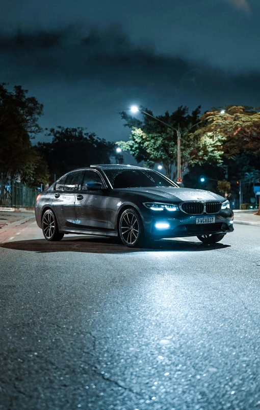 a gray sedan is parked at night in the city