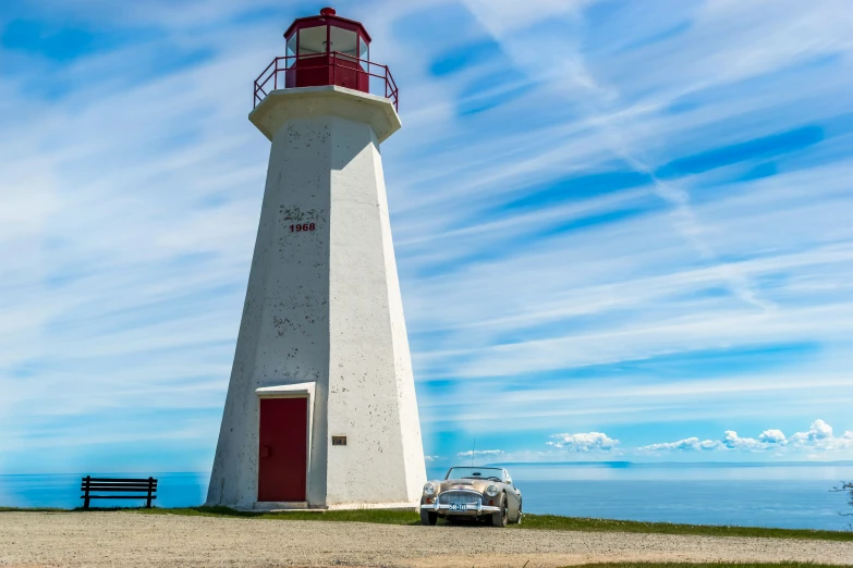 a person walking toward a white and red light house