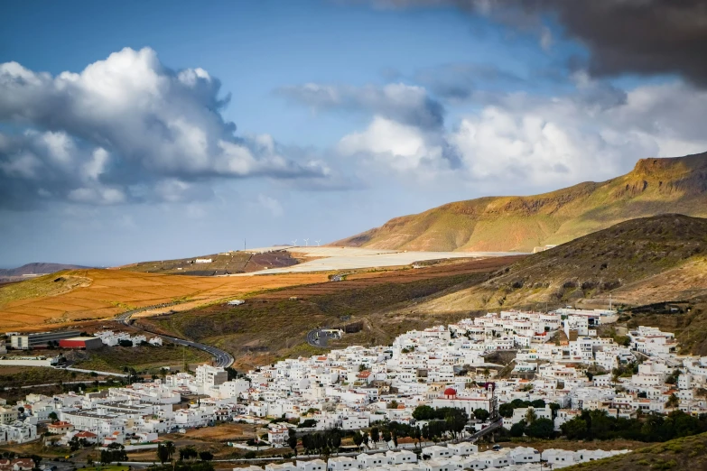 a large white village in the middle of some hills