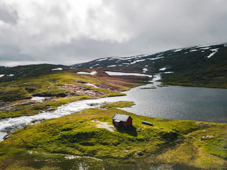 a small hut sits next to a body of water