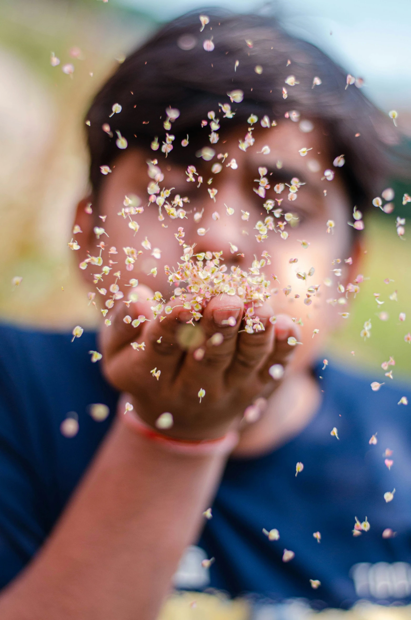 a child holding up a handful of glitter to the camera