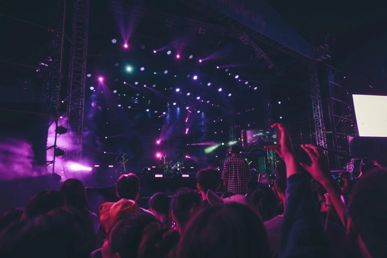 several people are on stage and some are holding their hands up