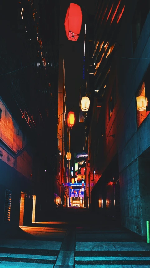 a narrow alley at night with light bulbs shining on