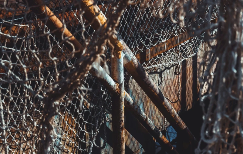 the top of a chain link fence has a rusted frame