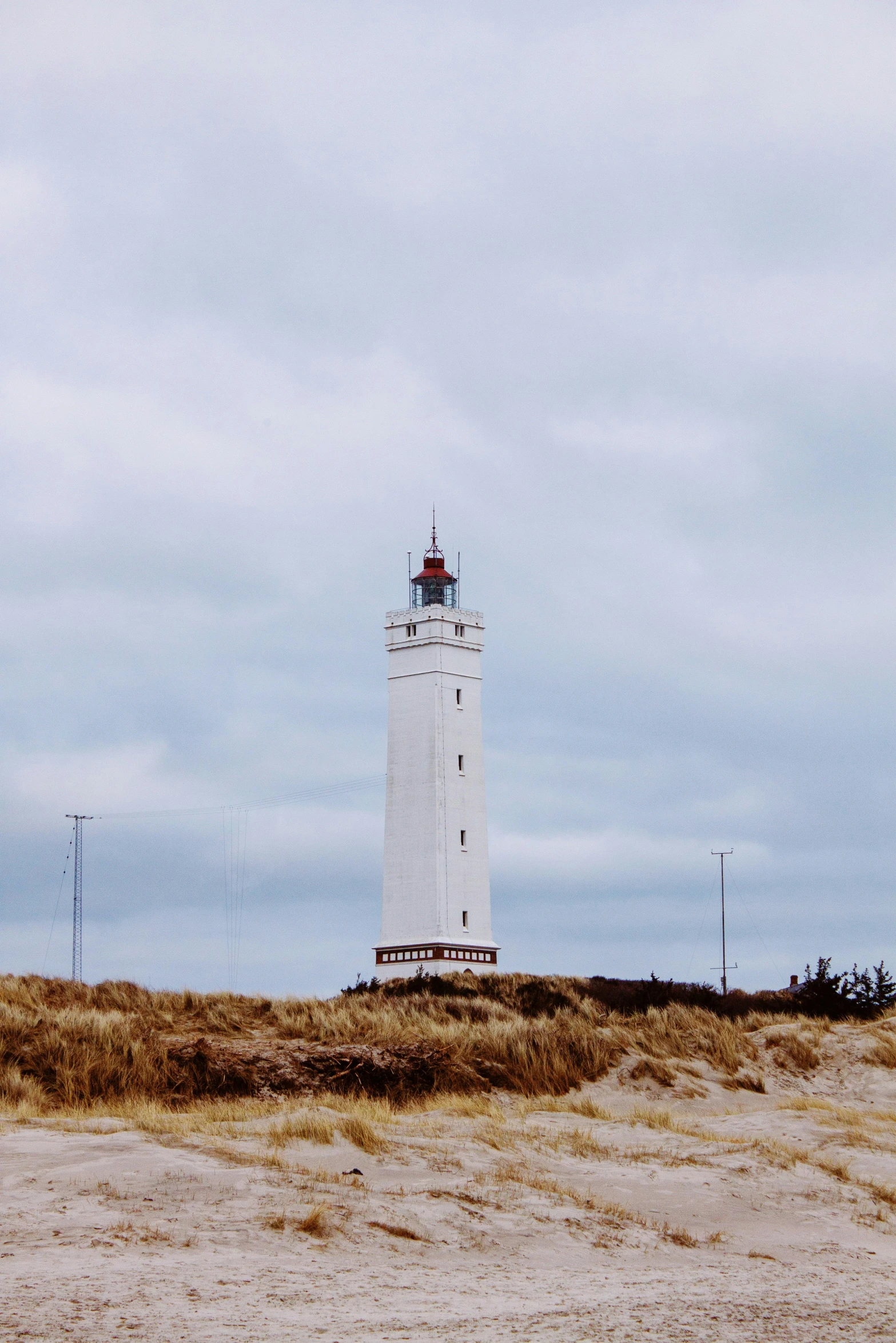 a light tower stands tall over a sandy field