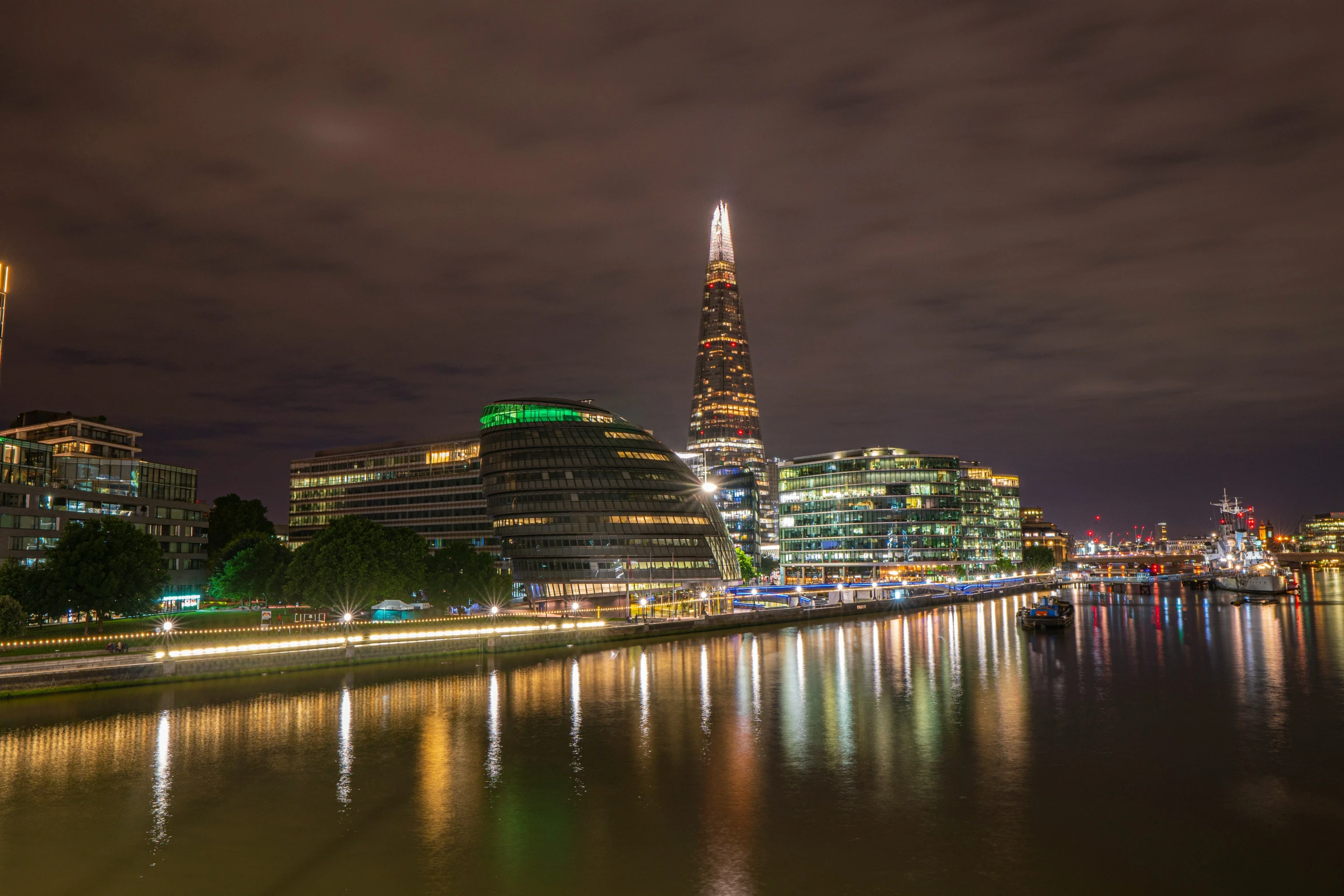 a river is shown with buildings lights and water