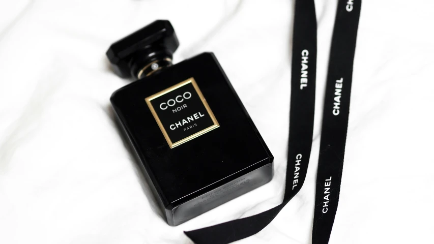 a lanyard camera that is next to a bottle of chanel