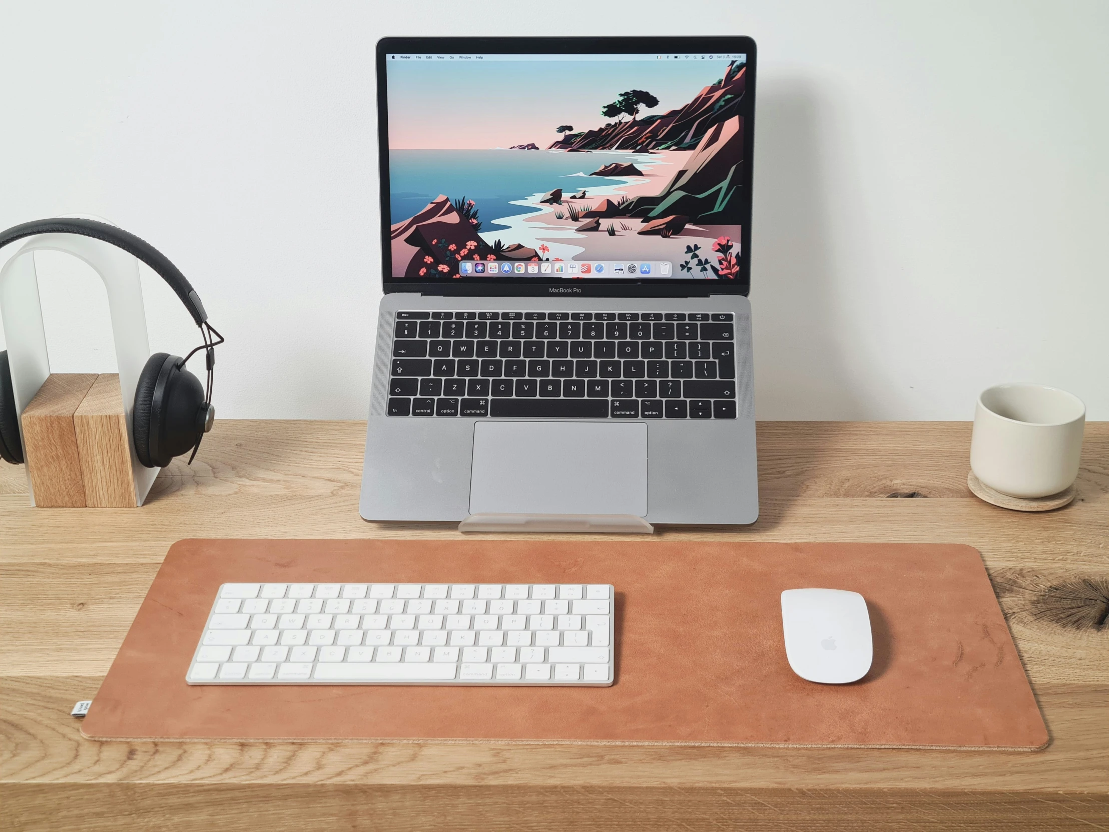 laptop computer with a mouse, headphones and an iphone sitting next to it