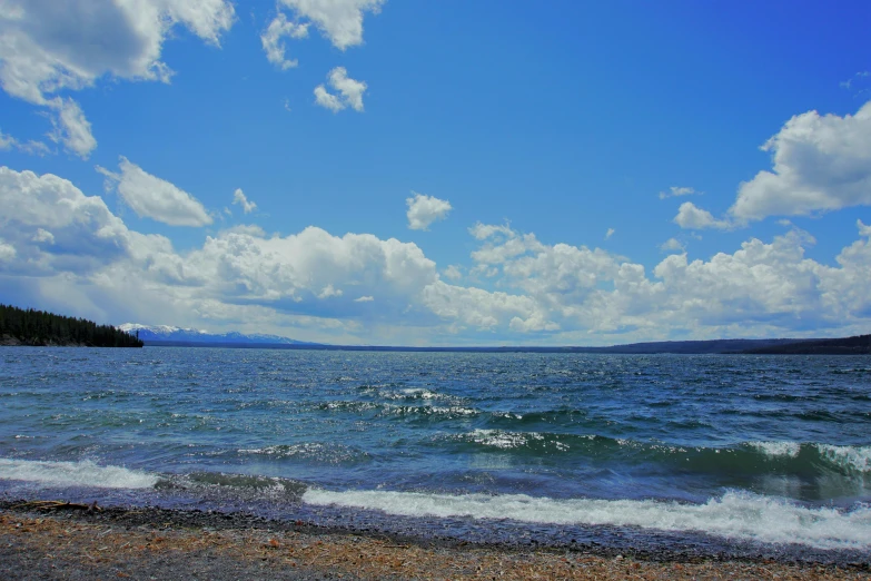 a person is standing on the shore as waves crash in front of them