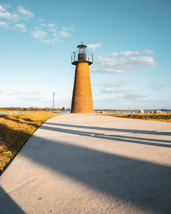 a very tall light house on a narrow road