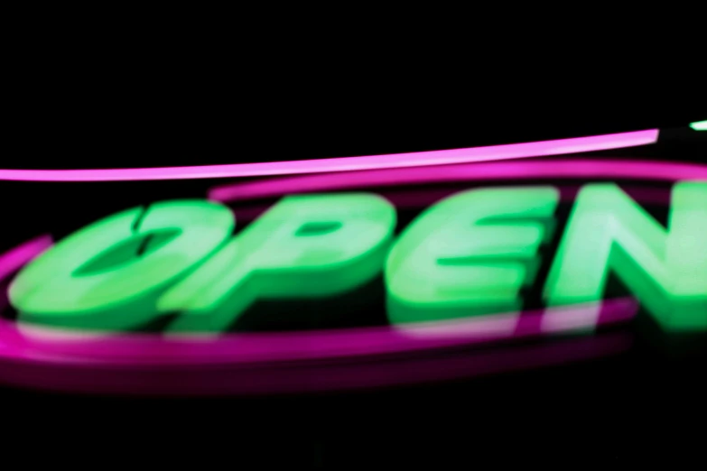 the neon neon sign for open is displayed in the dark