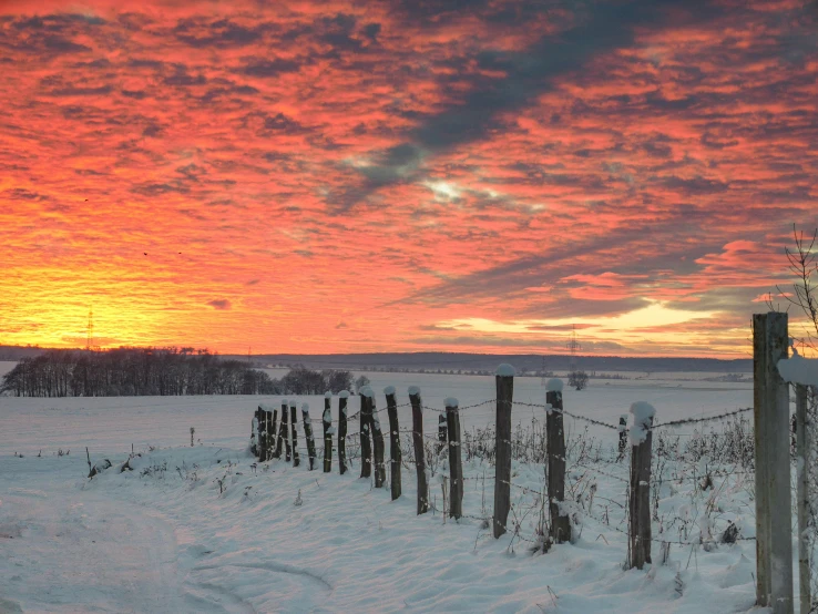 a fence on the field with snow on it