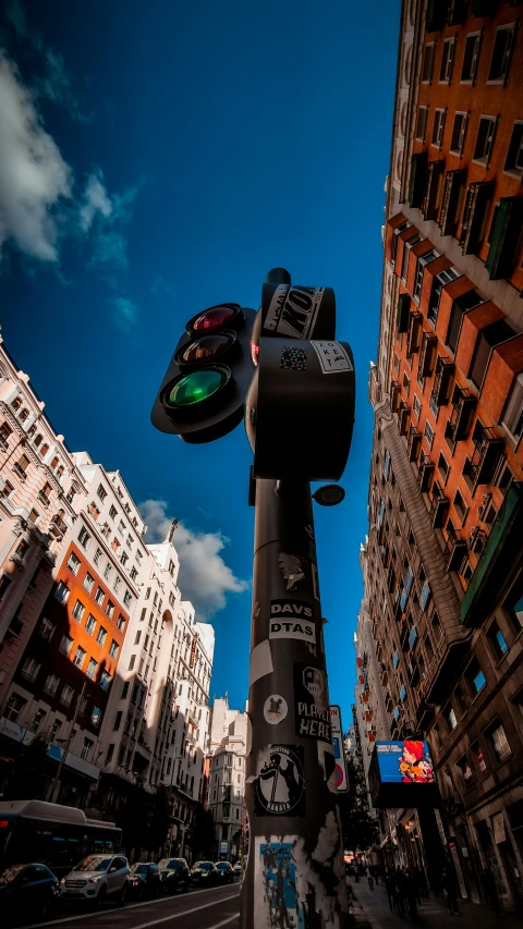 a city street with several tall buildings and one green traffic light