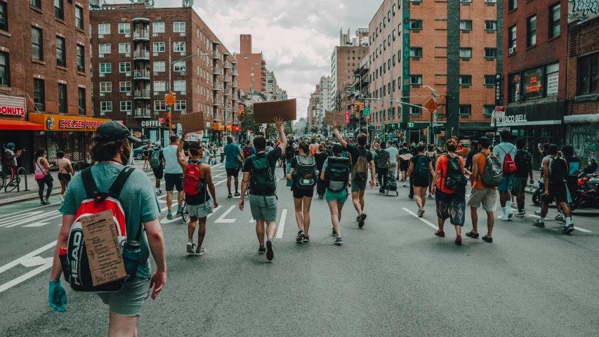 many people walk through the busy street near many buildings