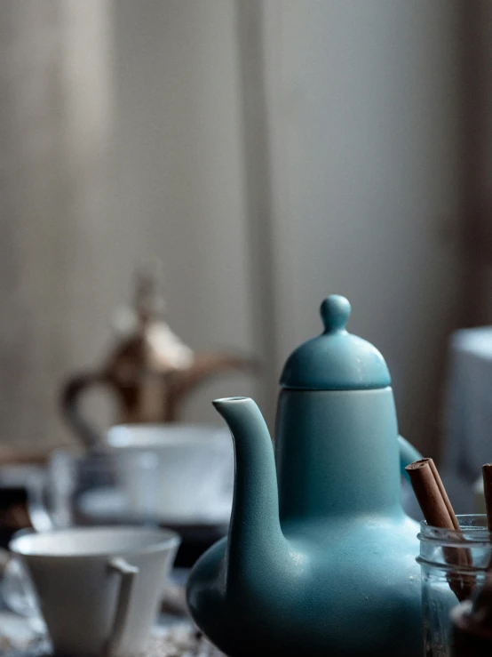 a teapot on a coffee table with other cups