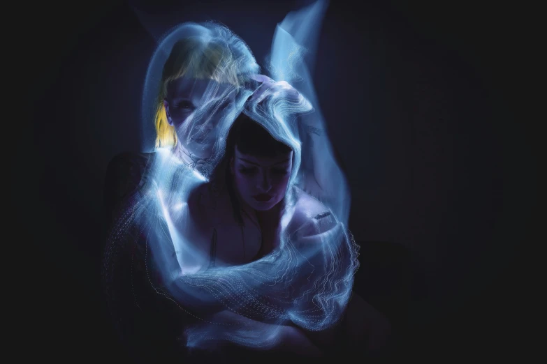 a woman is wrapped in blue, glowing fabric