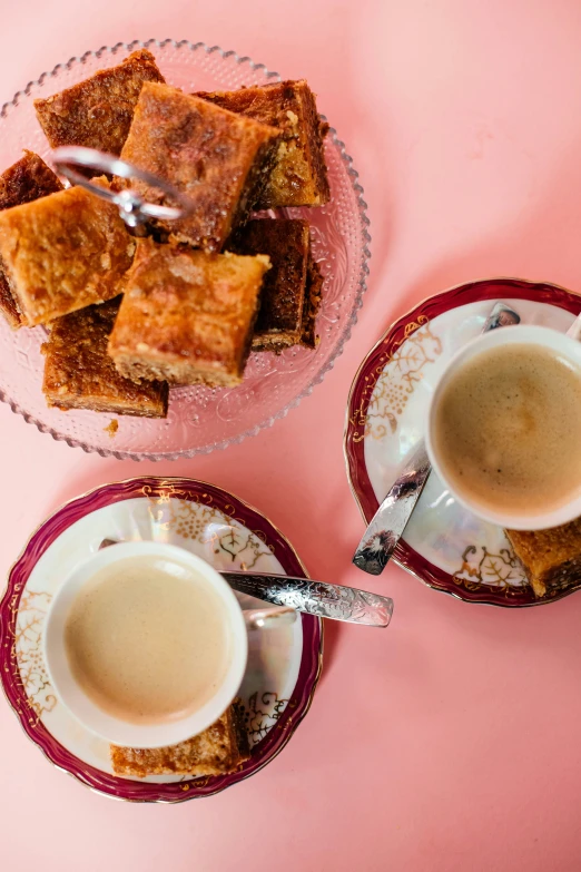 dessert on two plates with cups in front of them