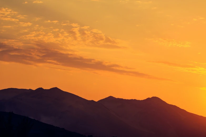 a plane that is flying in the sky with a view of a mountain range