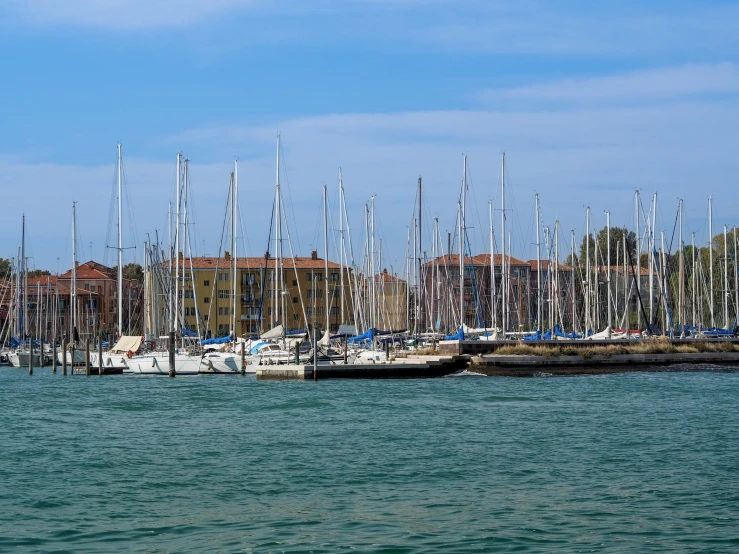 many sail boats are parked along a marina