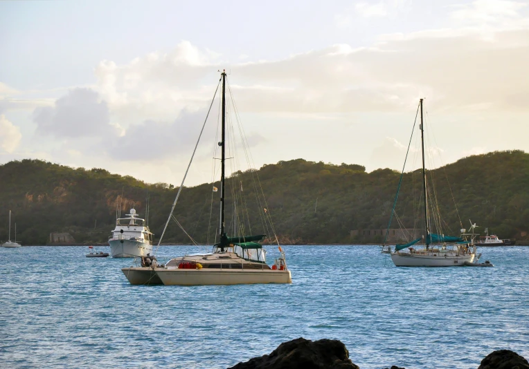 several boats in the ocean sailing toward shore