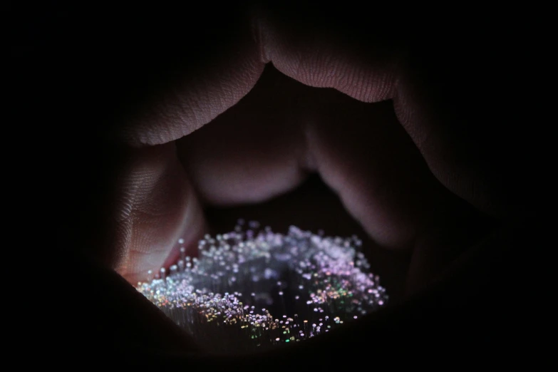 close up of hands holding a black circle filled with white and purple stars