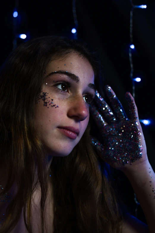 a woman with her hands covered in some glitter