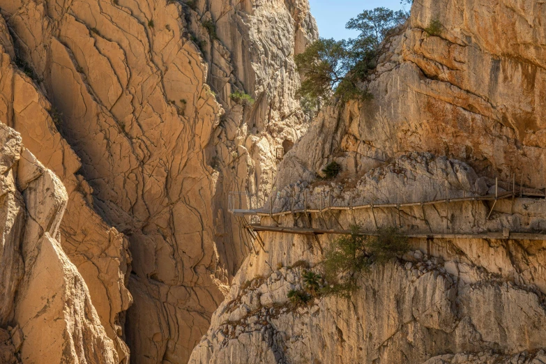 a narrow, long, rocky bridge on a long mountain side