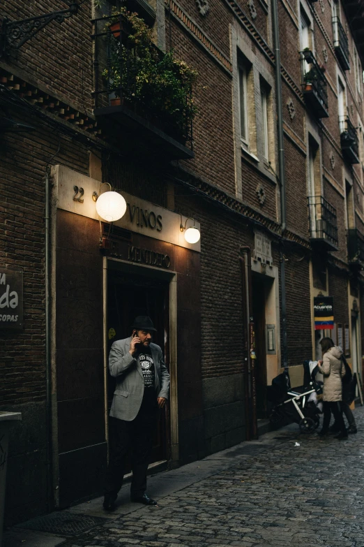 a man in a suit taking pictures of his business on the street