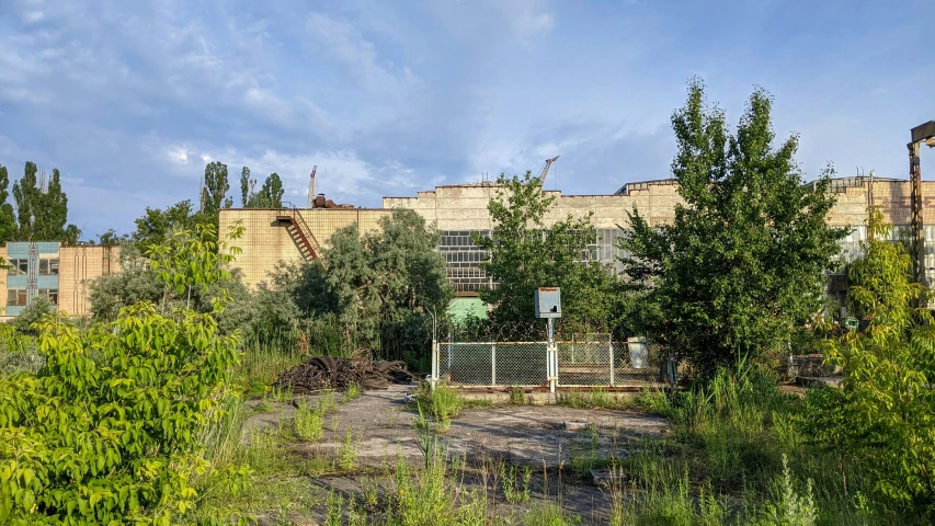 an old building is next to some very green bushes