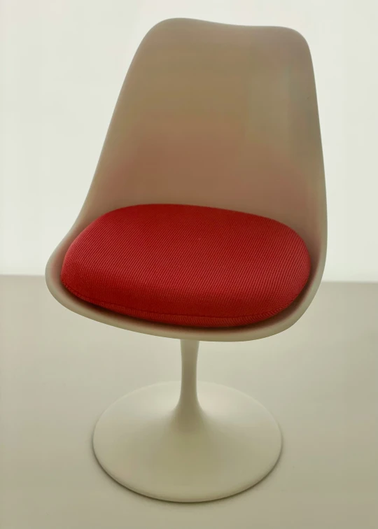 a red cushioned surface sits on top of an egg - shaped chair