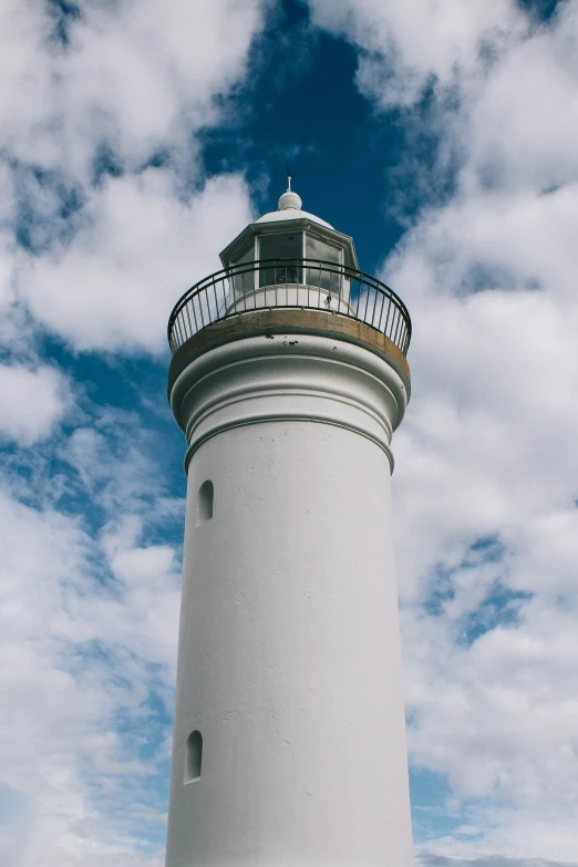 a white lighthouse with a bright red sign on the side of it