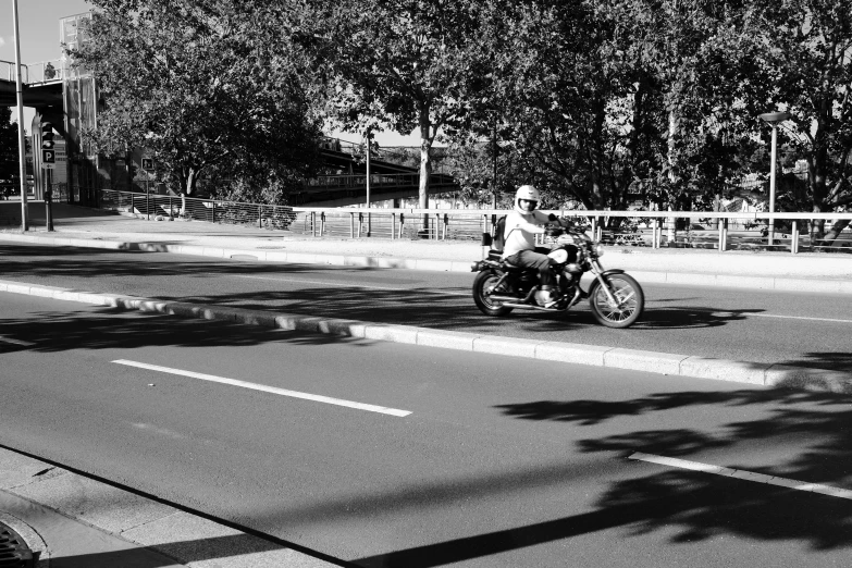 an old man driving a motorcycle down the street