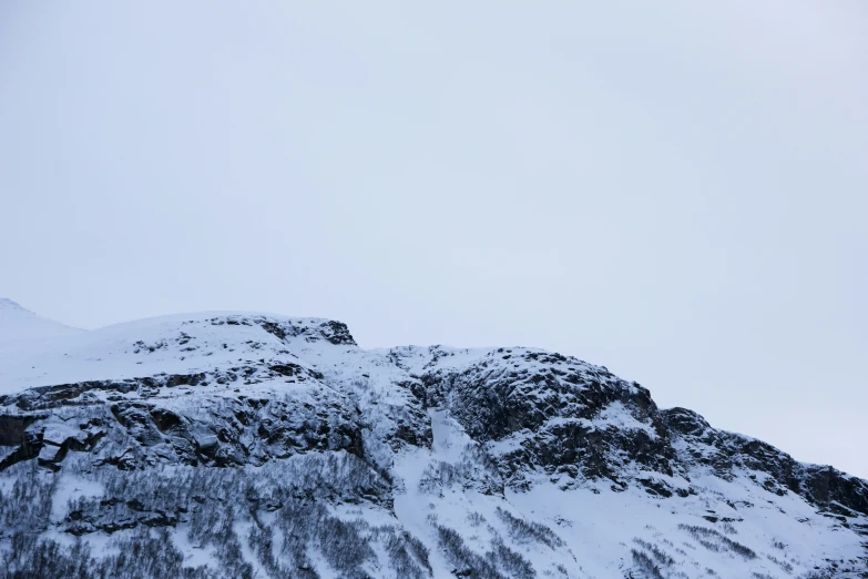 the snow covered mountain is almost completely obscured by the mist