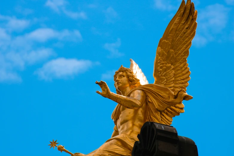 a gold angel statue atop a black post